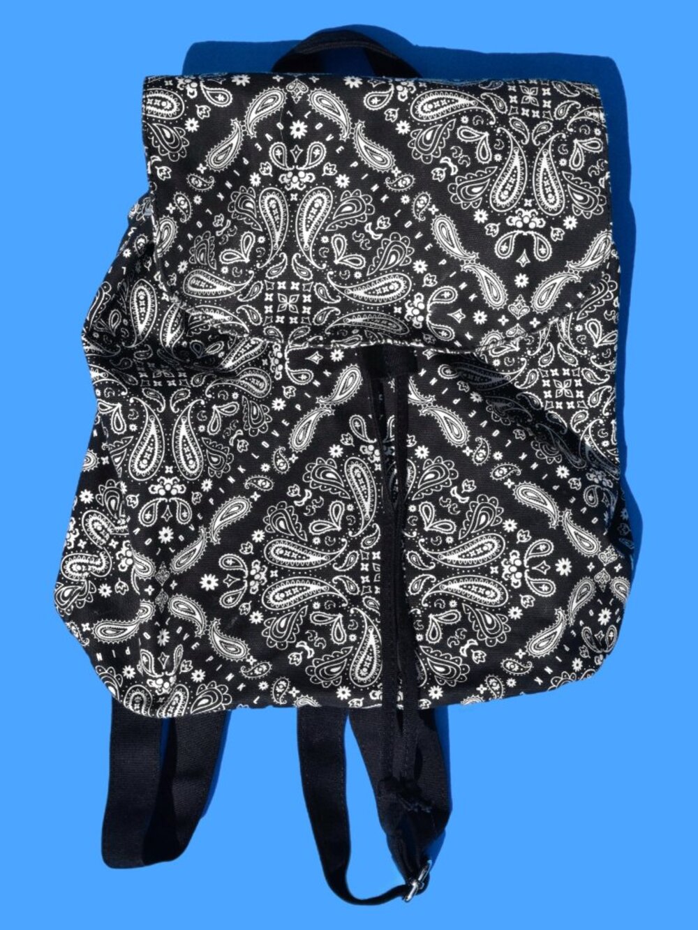Mini canvas backpack featuring a bold black-and-white bandana/paisley print. Per